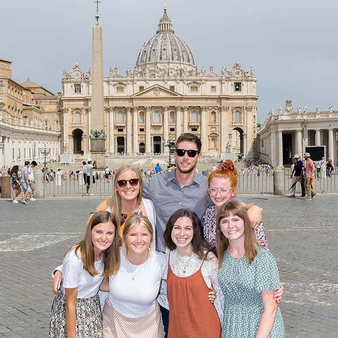 Group of smiling study abroad students in front of St. Peter’s Basilica in 罗马